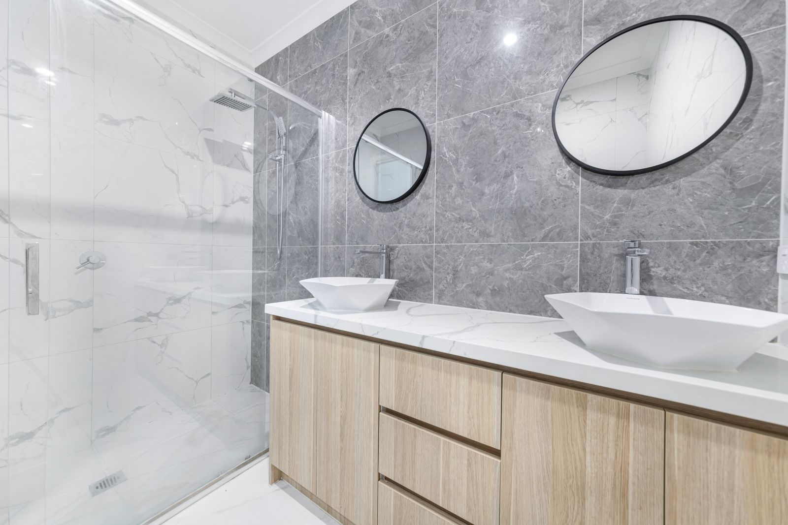 Renovated bathroom with tiled walk-in shower and a floating vanity