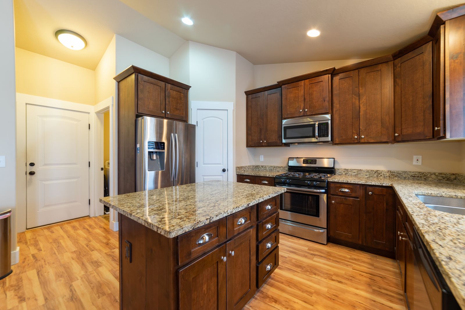 Renovated kitchen with an island, stone counters and new cabinetry