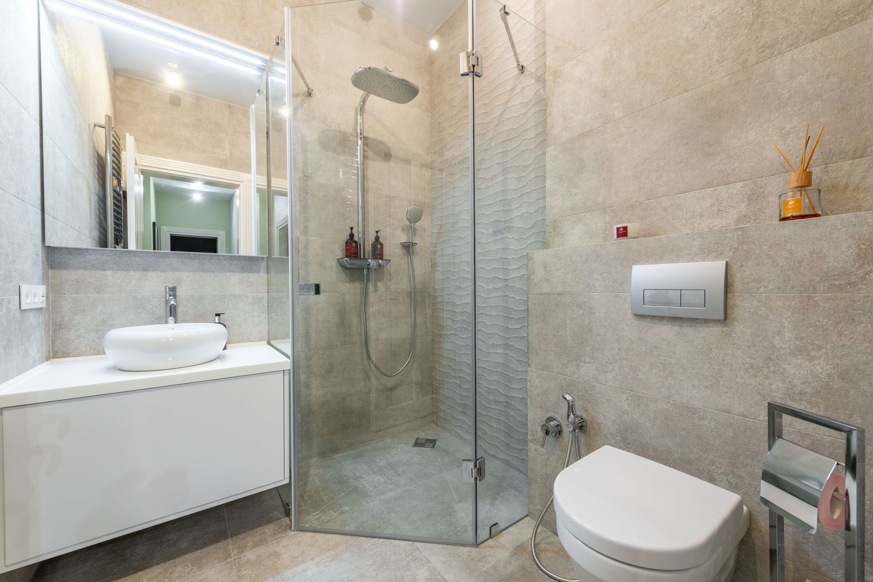 Shower room with a glass screen, rain shower head and wall-hung toilet